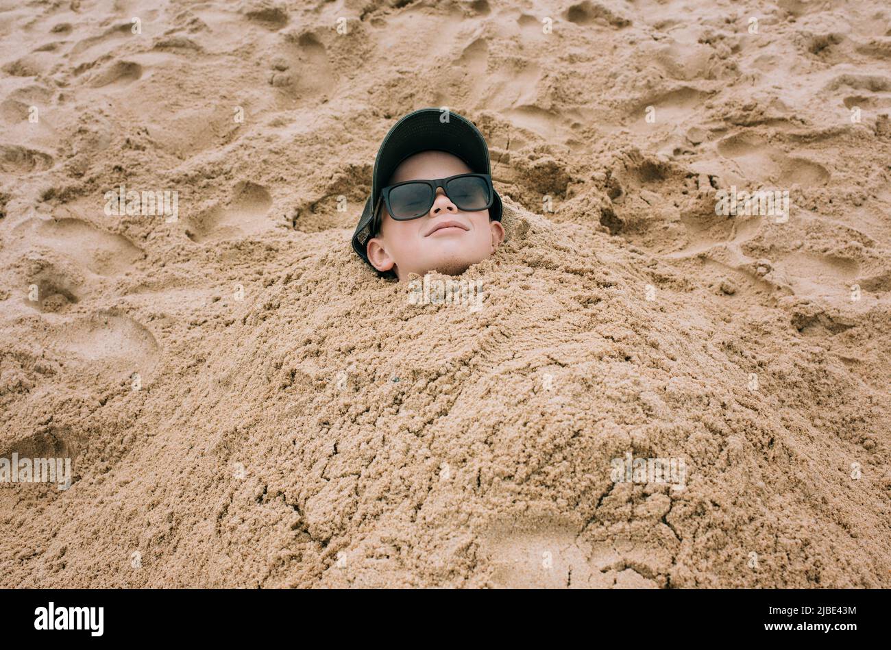 Boy buried in sand head hi-res stock photography and images - Alamy