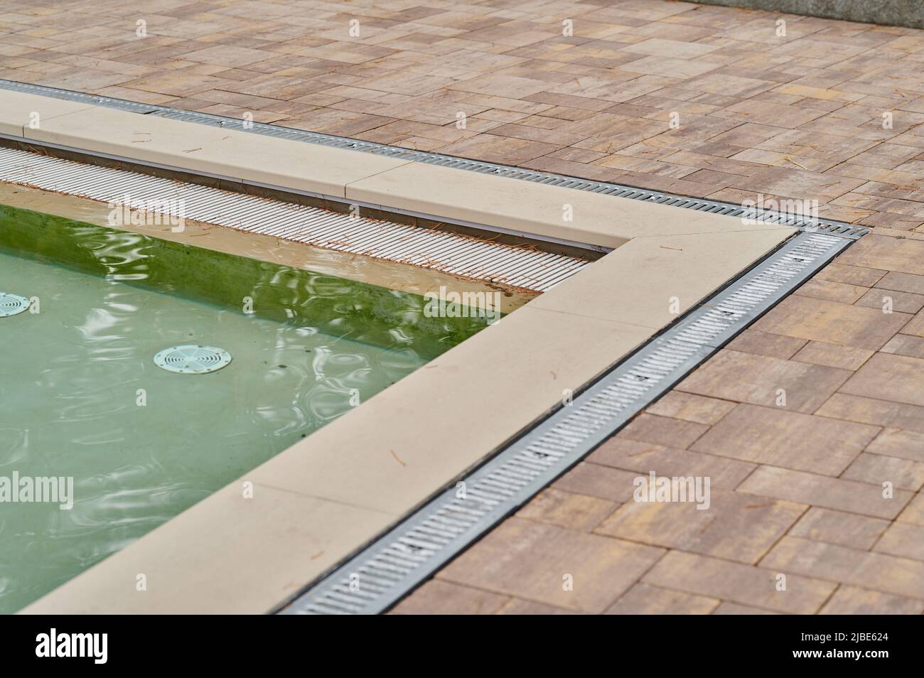 Walkway and ceramic tile with stone and metal gutter with grating