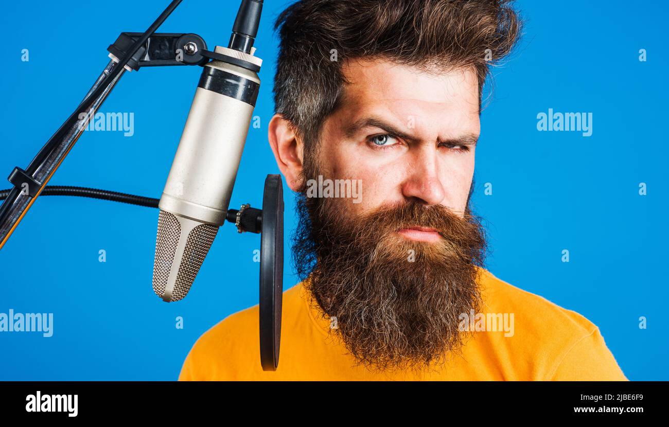 Singing in studio. Karaoke man. Male Professional vocalist sing in condenser microphone. Stock Photo