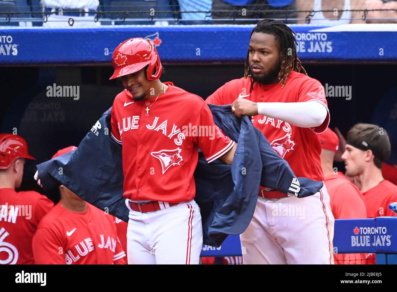 Toronto, Canada, June 5, 2022. Toronto Blue Jays' Santiago Espinal (5),  left, has ‚ÄúThe Home Run Jacket' put on him by Vladimir Guerrero Jr (27),  right, after hitting a three run home