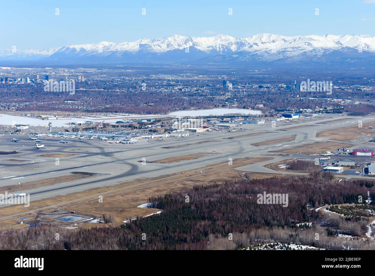 Anchorage Airport aerial view in Alaska, USA. Ted Stevens Anchorage International Airport seen from above. Airport with mountains behind. Stock Photo