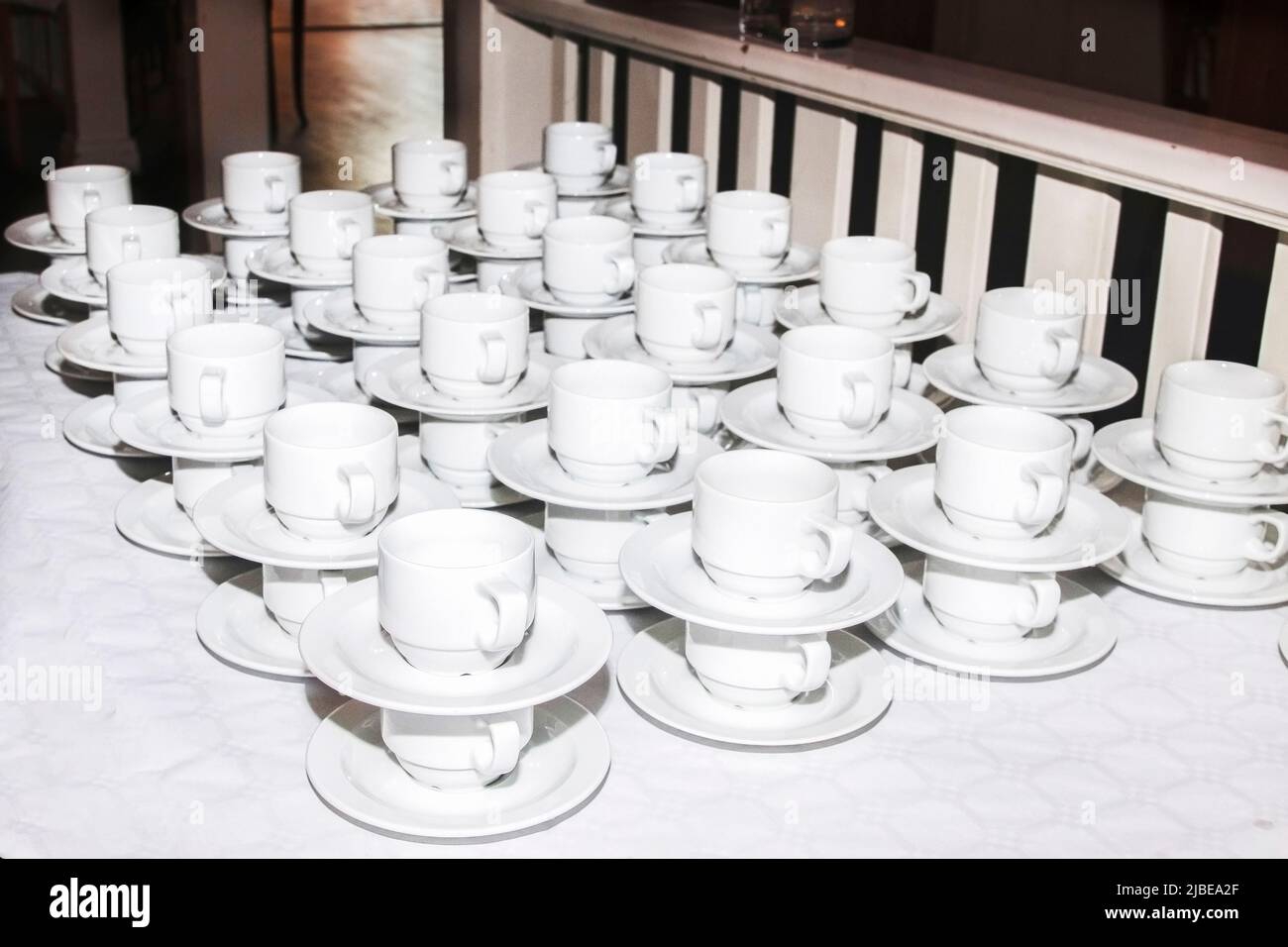 bar at an outdoor ceremony. Lots of cups and saucers on the table. pyramid of cups and saucers for the holiday. Tea cups catering and serving at a ban Stock Photo
