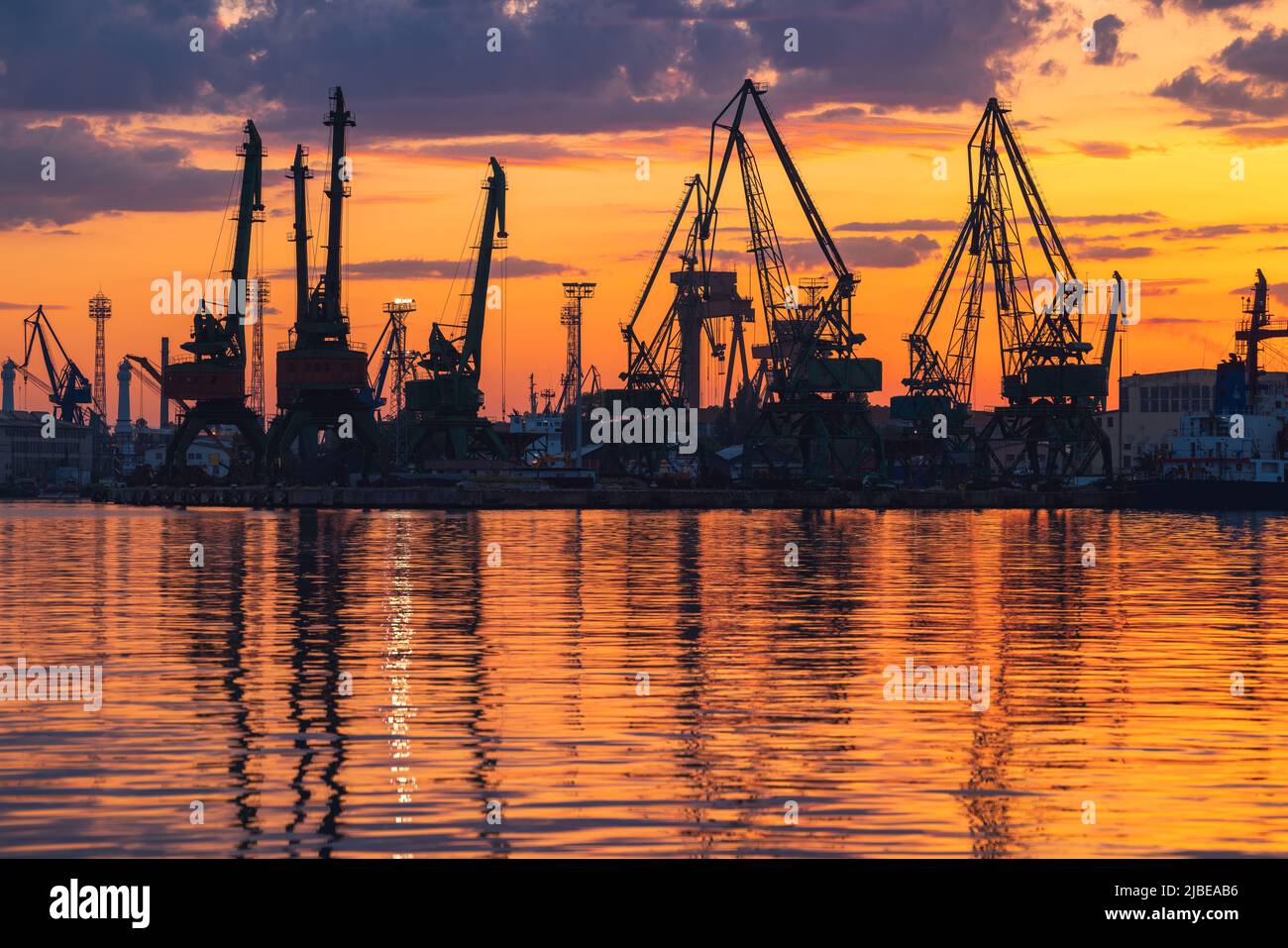 Colorful sunset over sea port and industrial cranes, Varna, Bulgaria Stock Photo