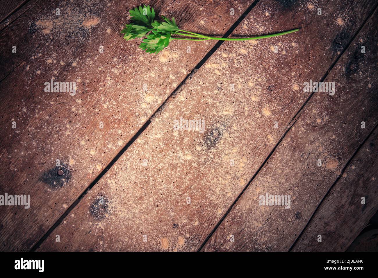 Vintage wooden table with flour and fresh herbs as food background Stock Photo