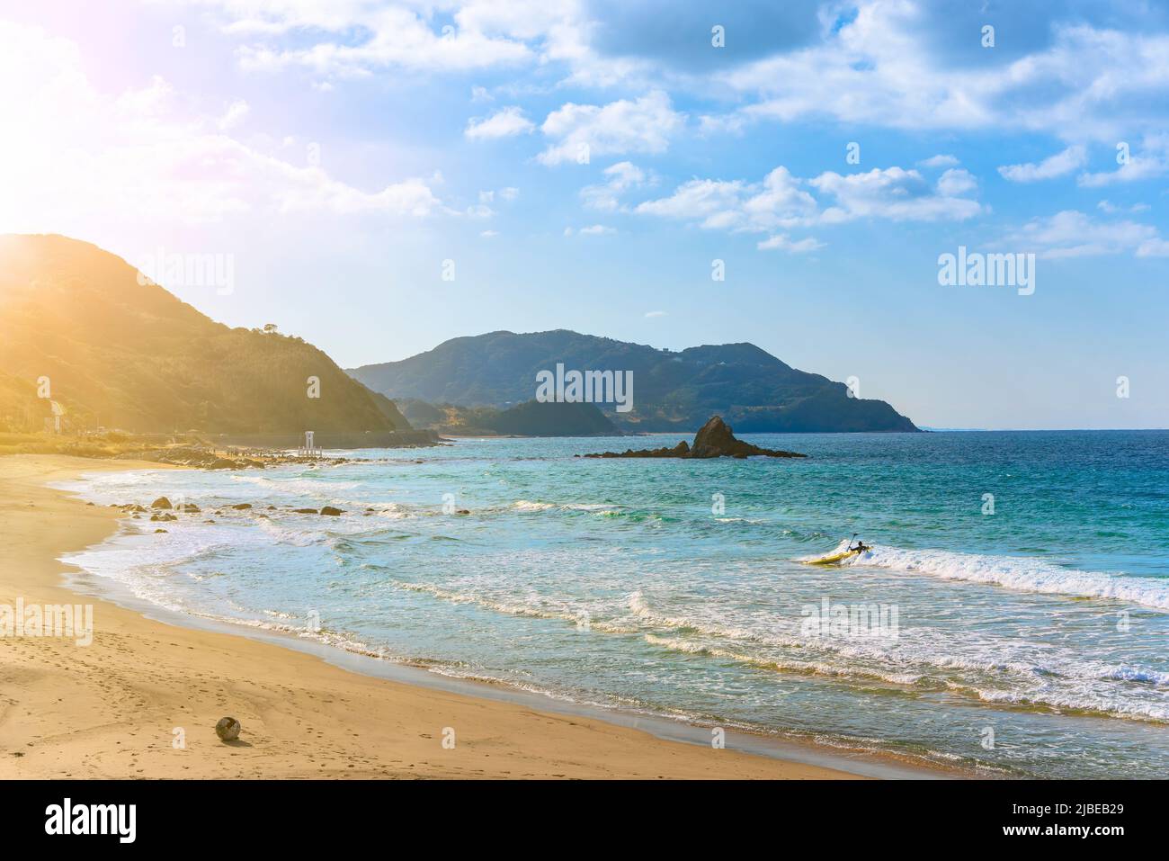 kyushu, japan - december 07 2021: Seascape of the Sakurai Futamigaura's Couple Stones and its famous torii gate in Fukuoka with a surfer making standu Stock Photo