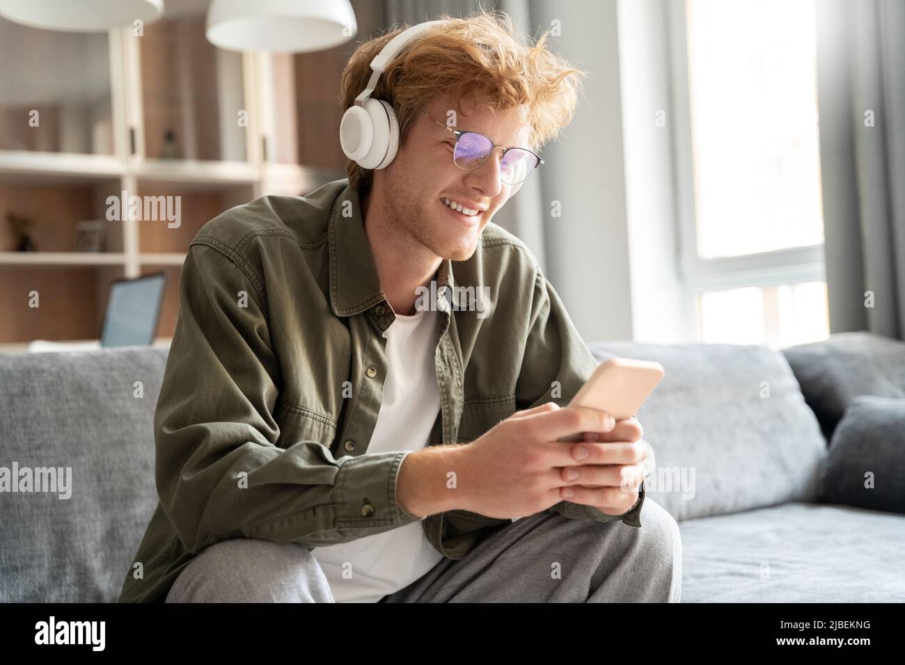 Young irish ginger man in headphone doing video call using smartphone Stock Photo