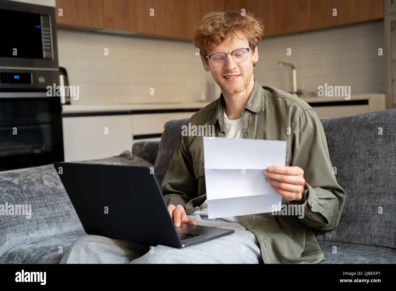 Ginger irish freelance man working with laptop and document at home office Stock Photo