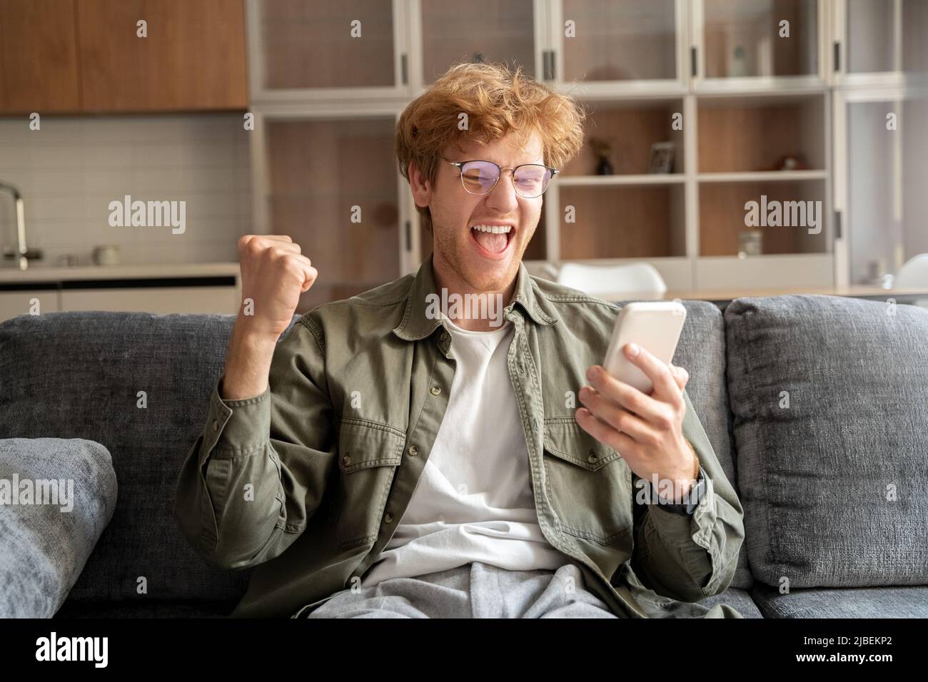 Excited young irish ginger man gesturing yes to mobile webcam Stock Photo