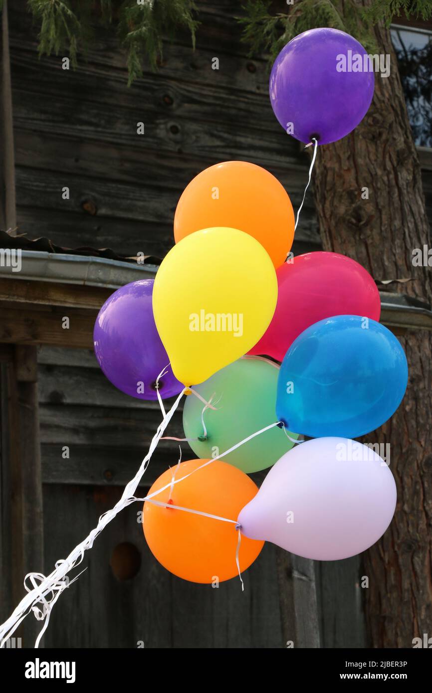 A bunch of bright, colorful balloons attract people to a yard sale. Stock Photo