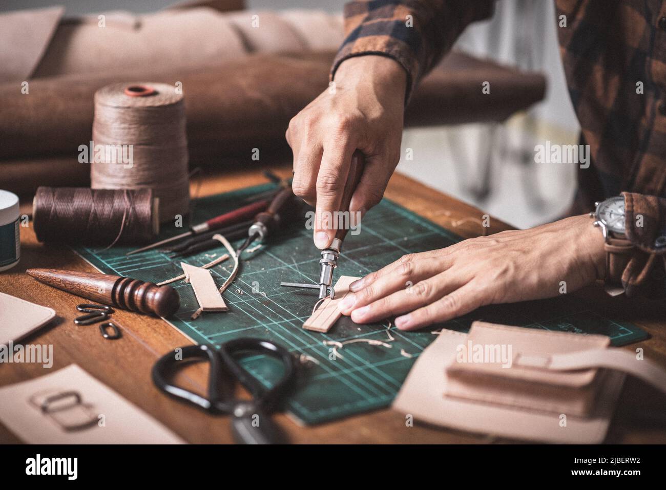 The man working with genuine leather in workshop. Stock Photo