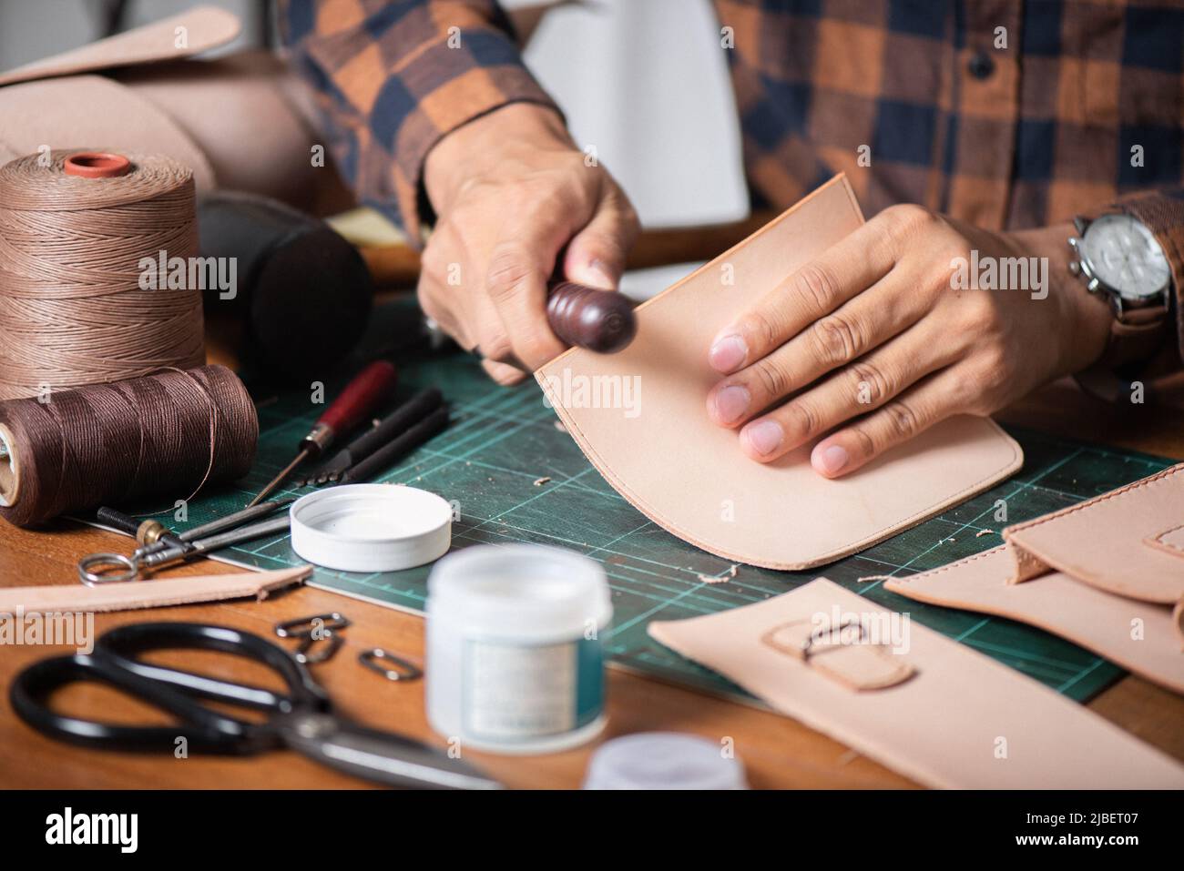 The man working with genuine leather in workshop. Stock Photo