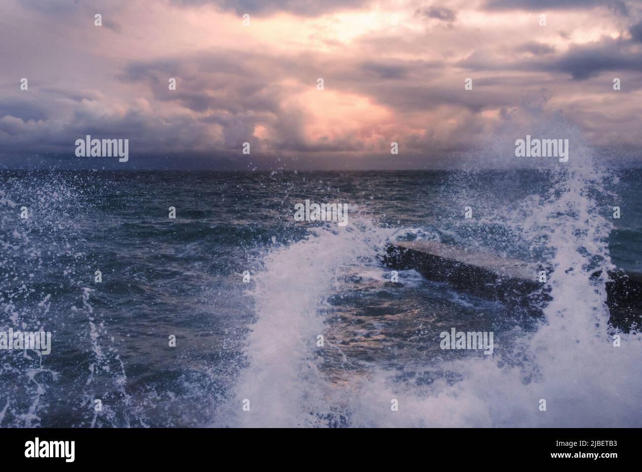 Storm at Black sea at sunset in spring. Sea view with waves during rain and cloudy in Alupka. Crimea. Soft focus Stock Photo