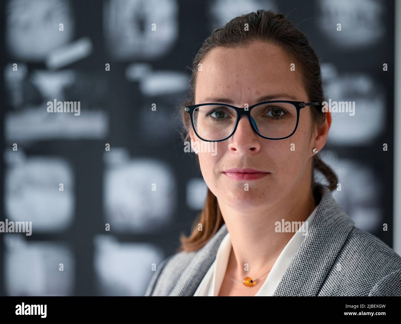 PRODUCTION - 24 May 2022, Saxony-Anhalt, Halle (Saale): Ulrike Vogel, archivist at the Stasi Unterterlagenarchiv in Halle/Saale stands in the photo exhibition 'Spurensuche'. In the series, the archive exhibits photographs that have not yet been assigned. The archivists hope for further information. (to dpa: 'Help needed for Operation 'Trace Search' in the Stasi Archive in Halle') Photo: Hendrik Schmidt/dpa Stock Photo