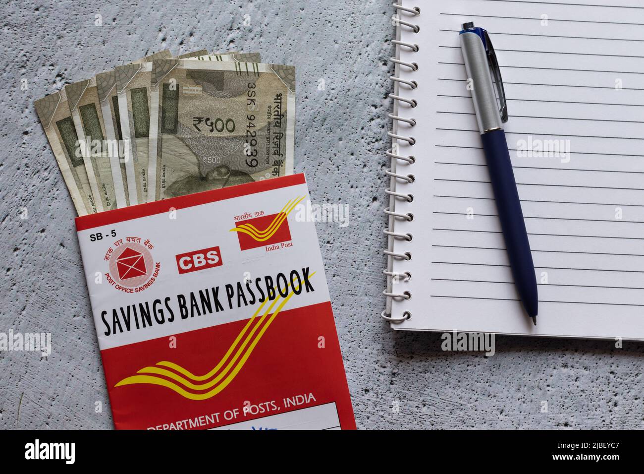 Birbhum, West Bengal, India - 25 April 2022: Top view of Indian post office savings books, currencies, pen and note book Stock Photo