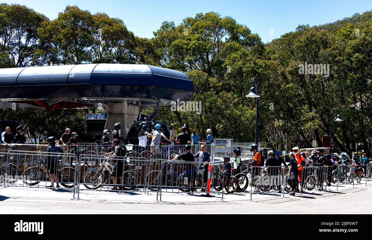 Mountain bikers queue for chair lift at Thredbo to take them and their bikes to Eagles Nest at the top of the mountain for the exciting ride back down Stock Photo
