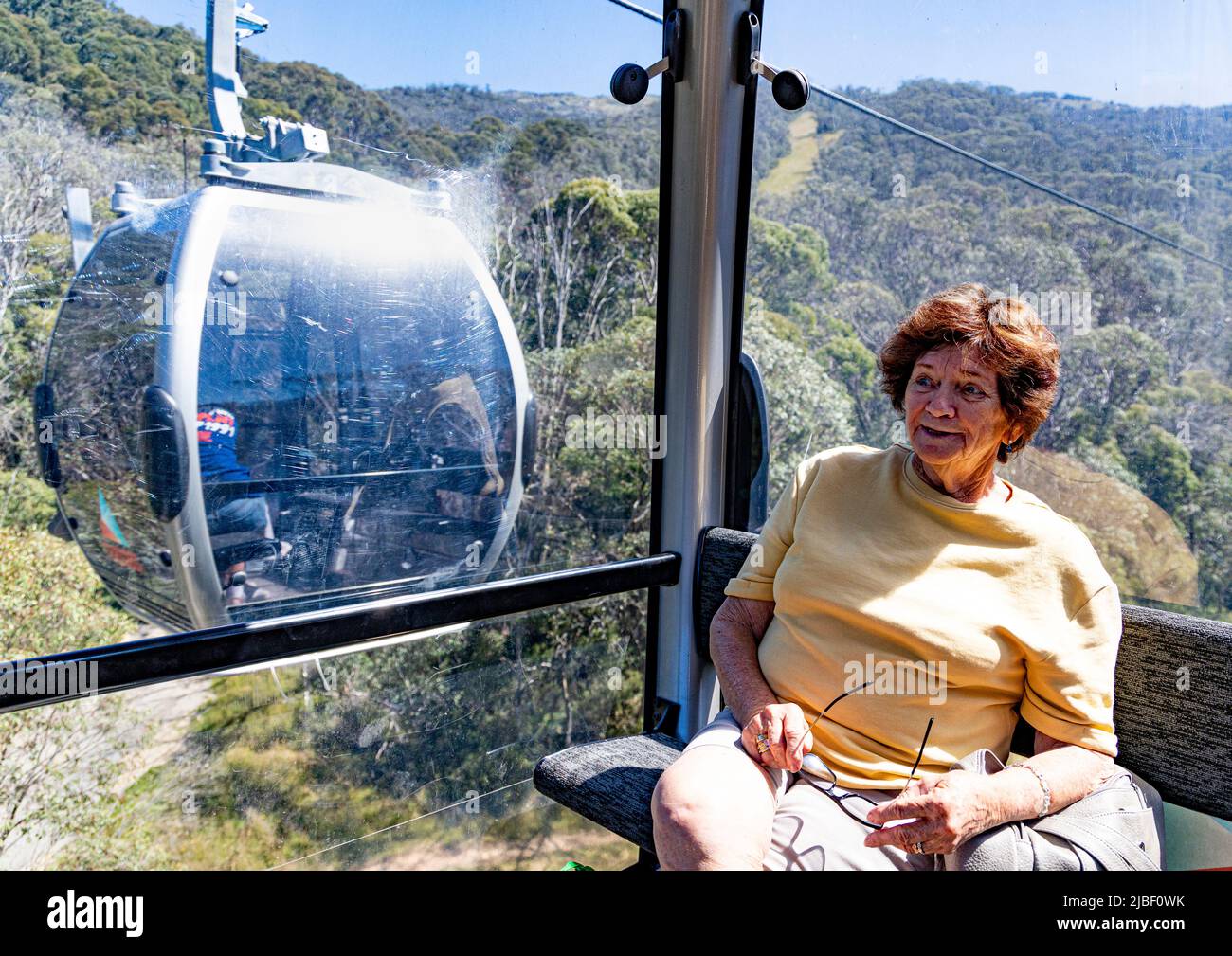 single; lone;  female; woman;  tourist; riding in gondola; Thredbo; sunny day; scenic ride; Stock Photo