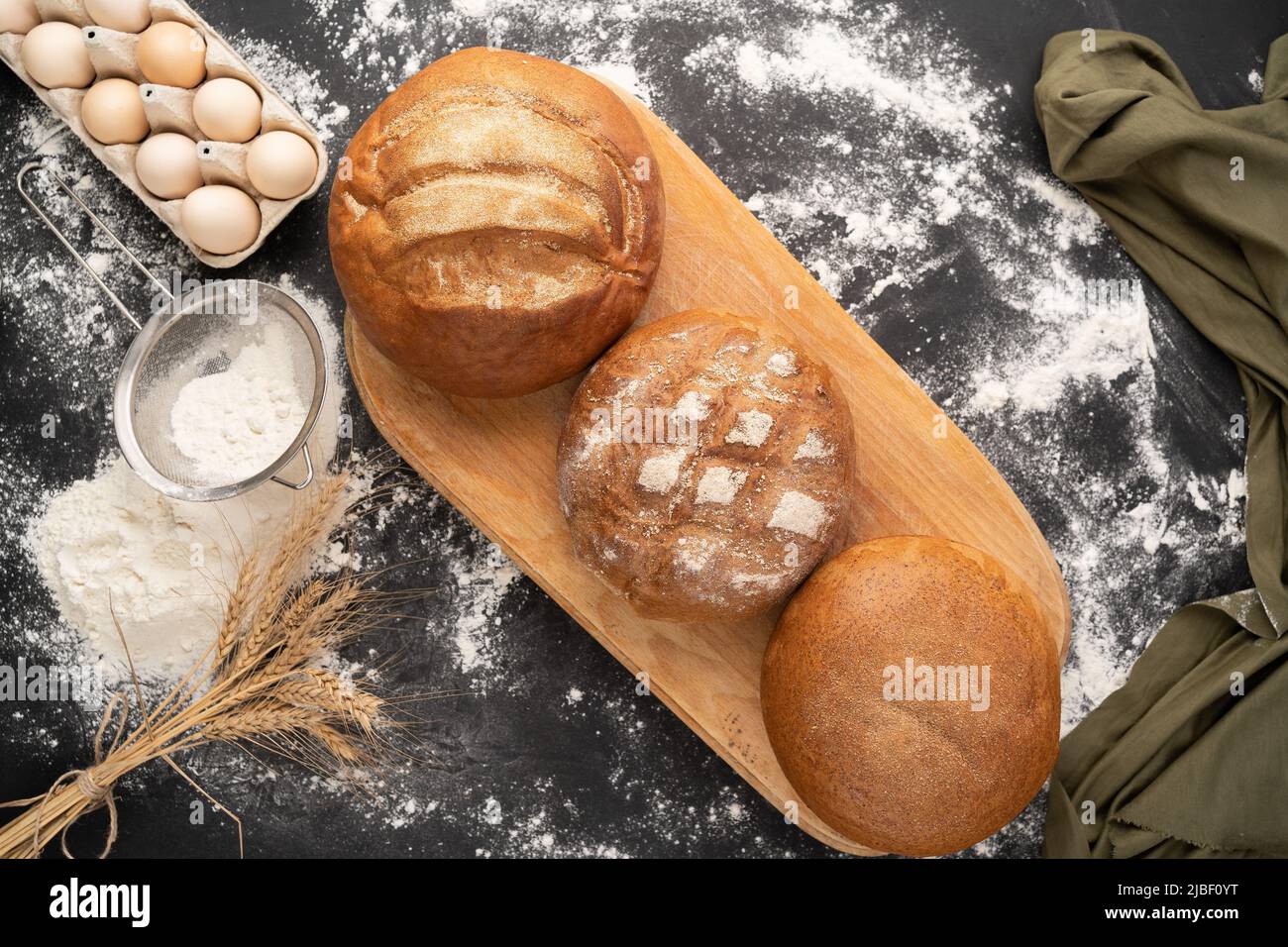 three round natural breads with wheat and rye flour. variety of bakery ...