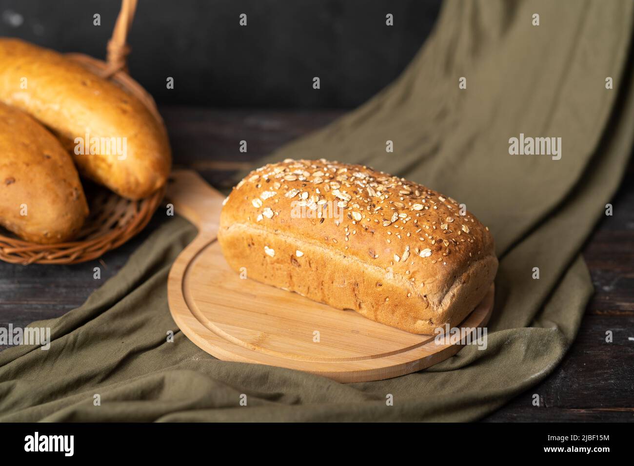 whole wheat bread on dark rustic wooden background, bio ingredients Stock Photo