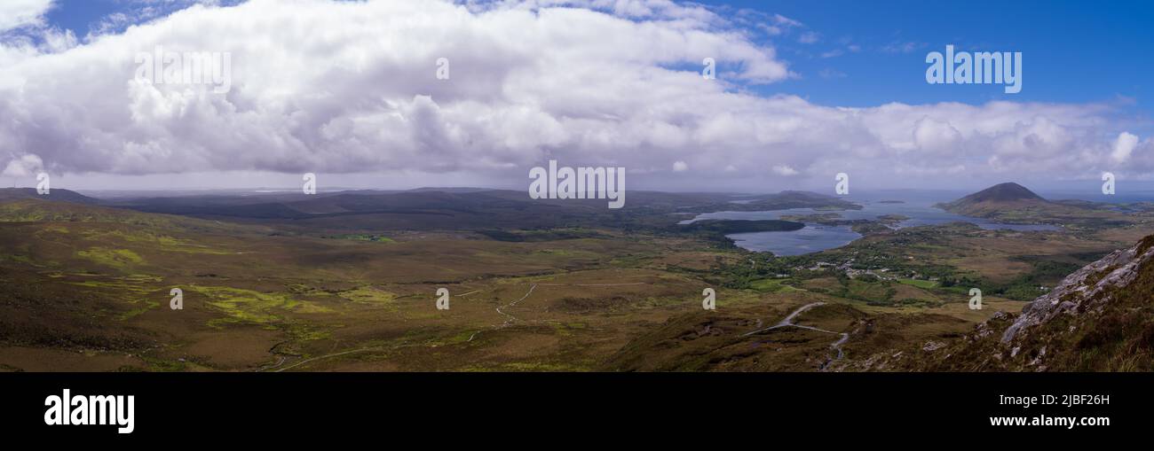 scenic panoramic vista over Connemara National Park with white clouds and blue sky in Spring Stock Photo