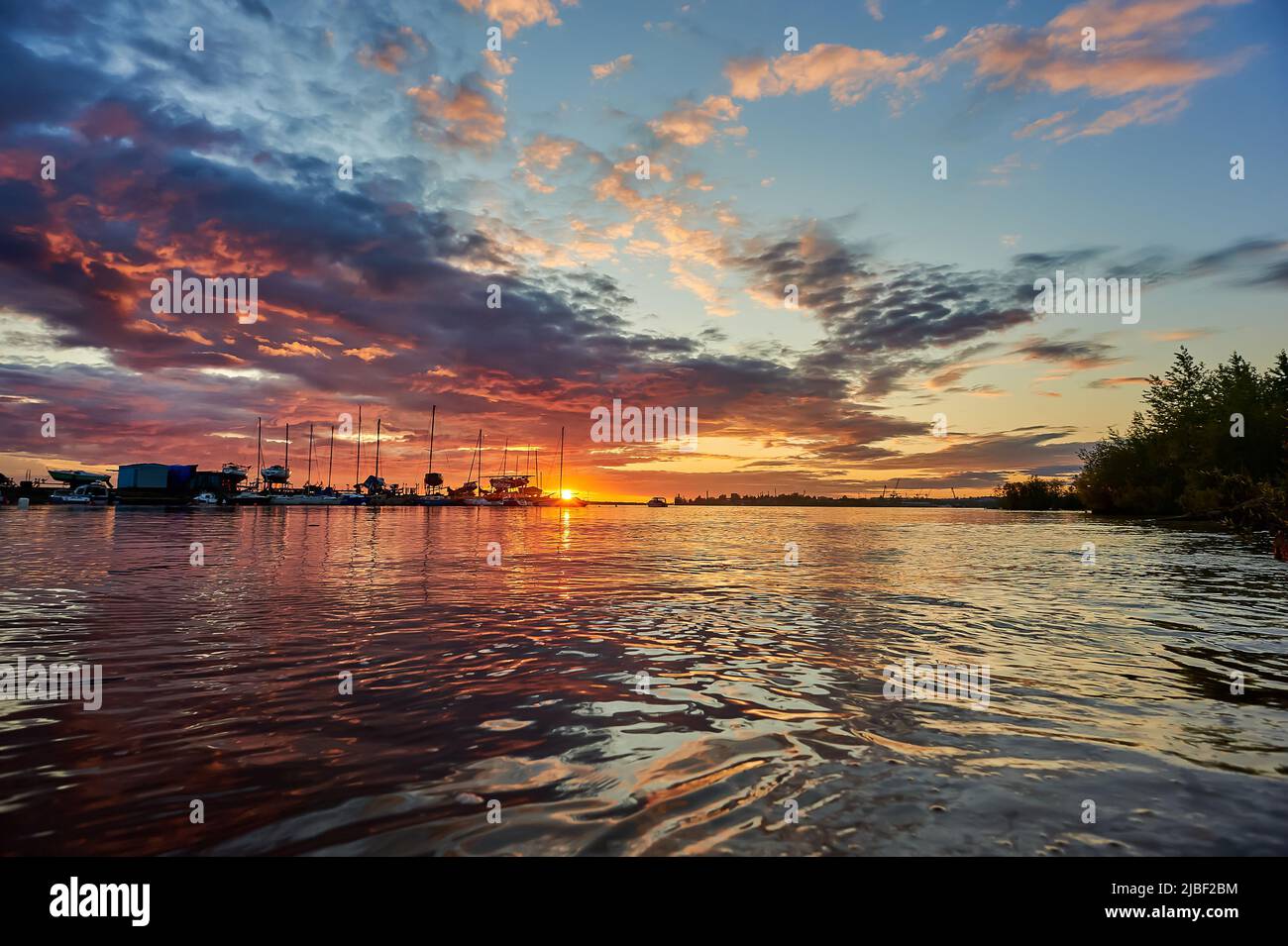 beautiful sunset on the sea on the background of yachts Stock Photo - Alamy