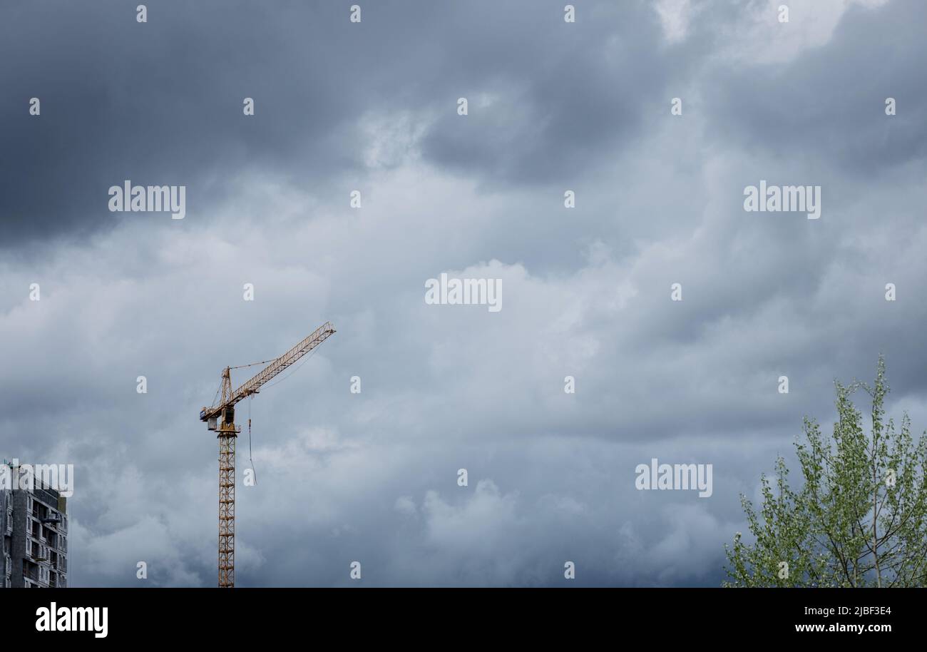 Construction crane with a dark cloudy sky in the background Stock Photo ...