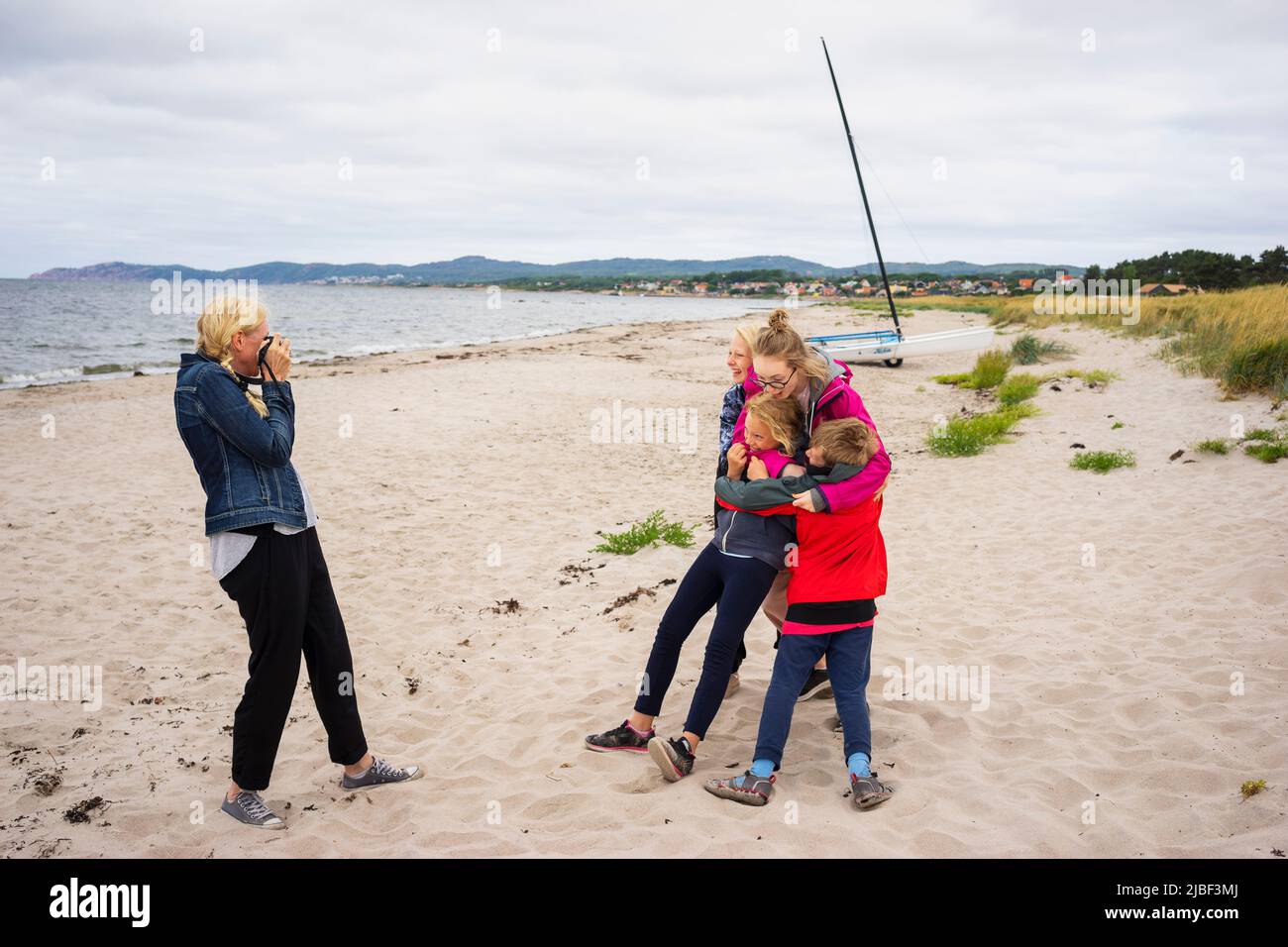 Woman photographing her children on beach Stock Photo