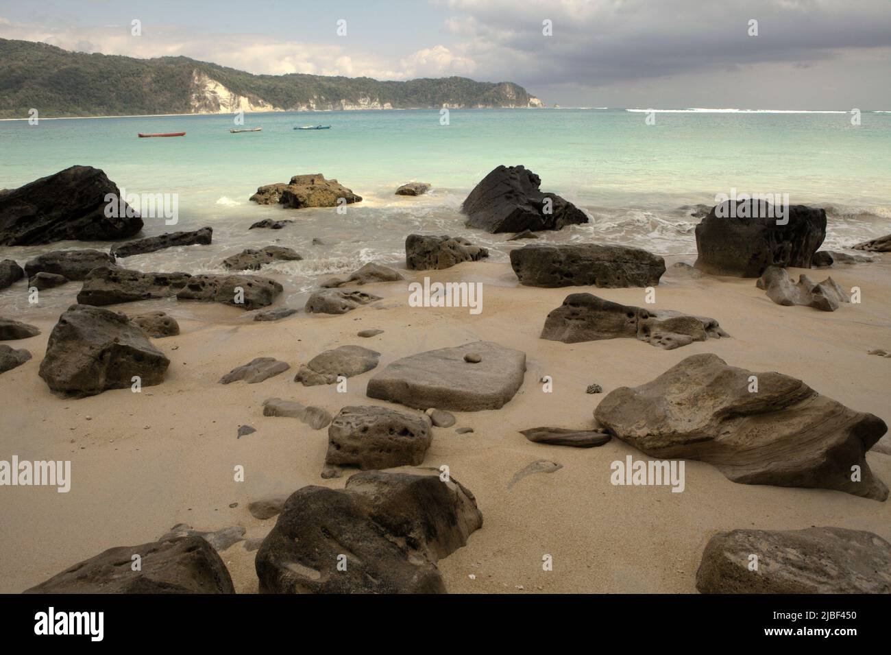 Rocks on sandy beach of Tarimbang in Tabundung, East Sumba, East Nusa Tenggara, Indonesia. This beach could be among the half of sandy beaches in the world that could disappear by the end of century if climate change continues unmitigated, as reported by climate scientists in their March 2020 publication on Nature Climate Change. Stock Photo