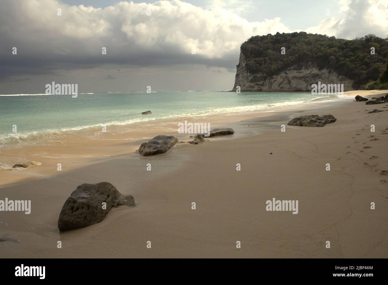 Rocks on sandy beach of Tarimbang in Tabundung, East Sumba, East Nusa Tenggara, Indonesia. This beach could be among the half of sandy beaches in the world that could disappear by the end of century if climate change continues unmitigated, as reported by climate scientists in their March 2020 publication on Nature Climate Change. Stock Photo