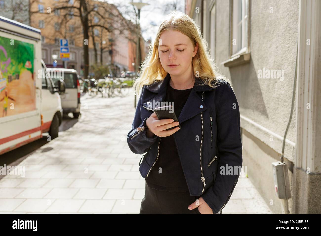 Young woman using smart phone in Stockholm, Sweden Stock Photo