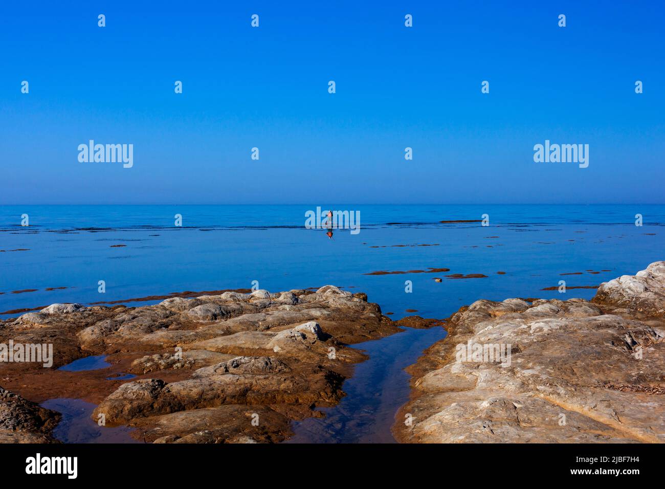 Scenic view of Sicily sea where an elderly man fishing with sticks Stock Photo