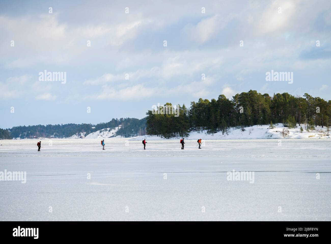 People ice skating on frozen lake Stock Photo