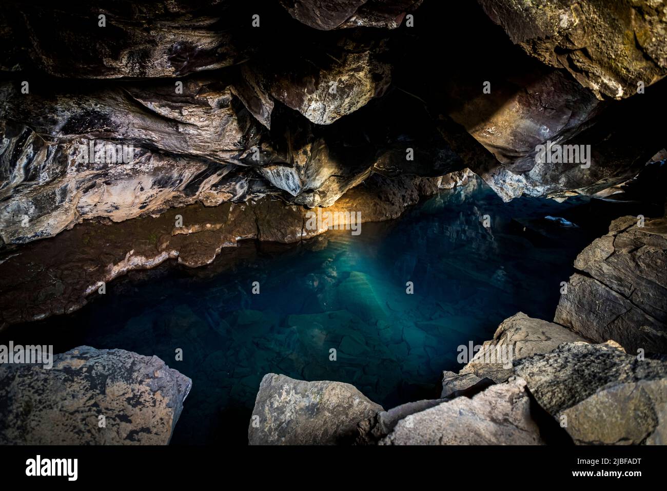Grjótagjá (engl.: 'crevice') is a cave with a small lake in Iceland. Above ground, the fault zone between the continental plates is visible Stock Photo