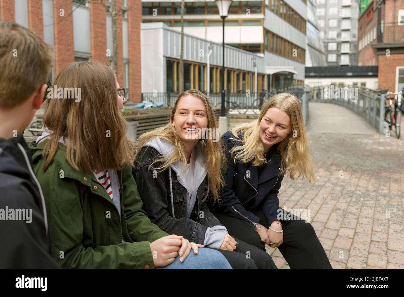 Friends sitting on bench in Stockholm, Sweden Stock Photo