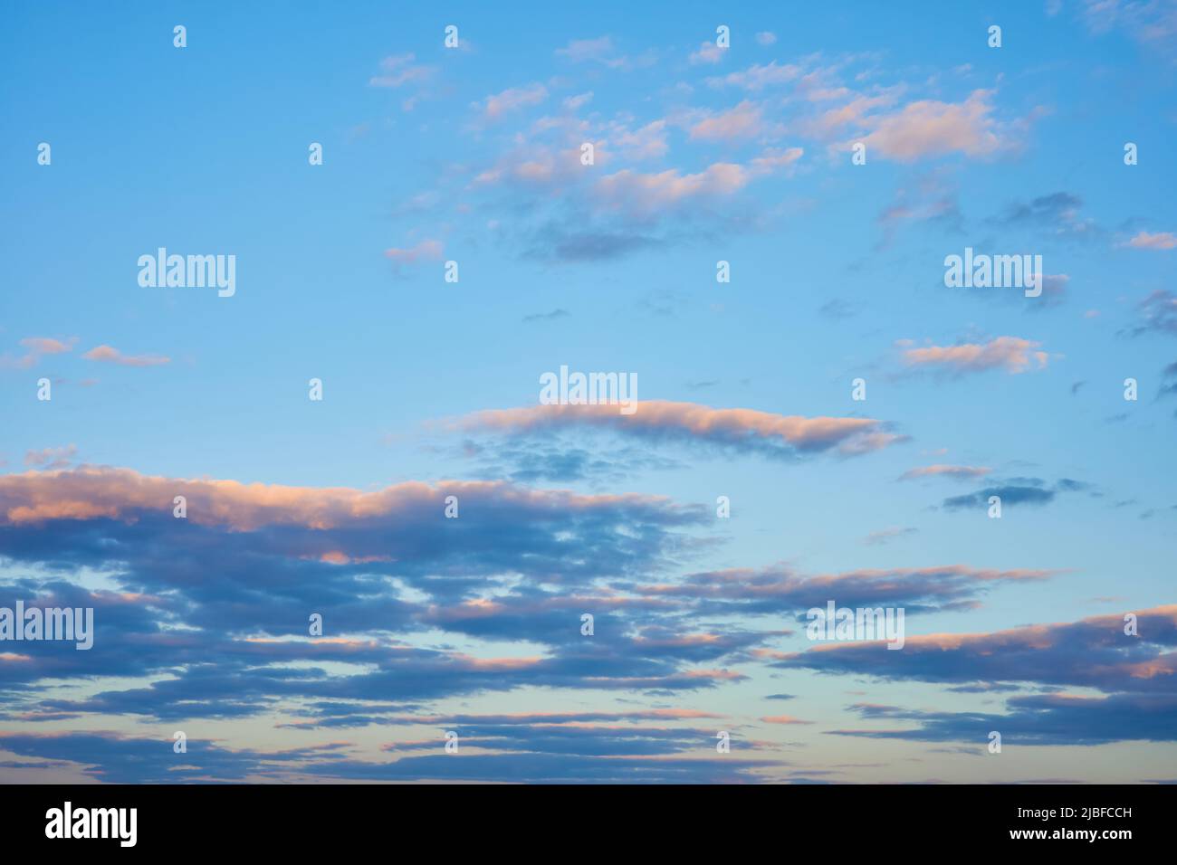 Colorful clouds in the blue sunset sky Stock Photo - Alamy