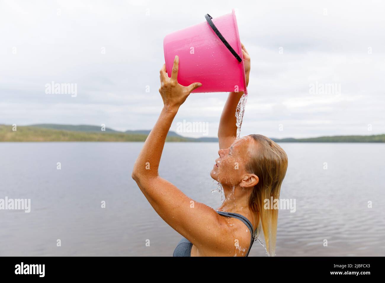 Woman bathing with bucket of water from lake Stock Photo Alamy