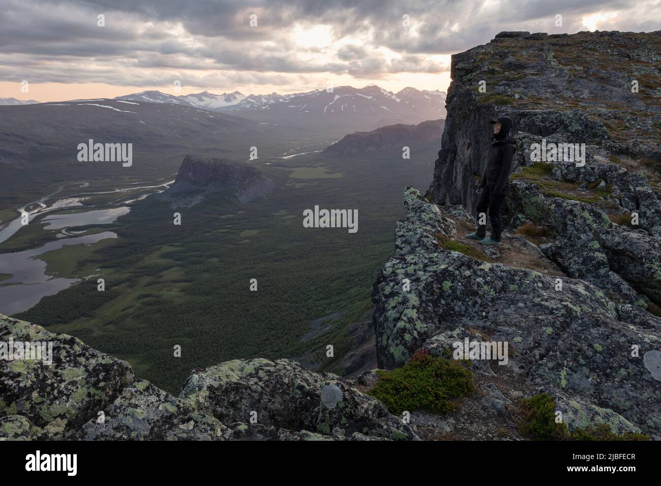 Woman standing on cliff above Rapa Valley in Sarek National Park, Sweden Stock Photo