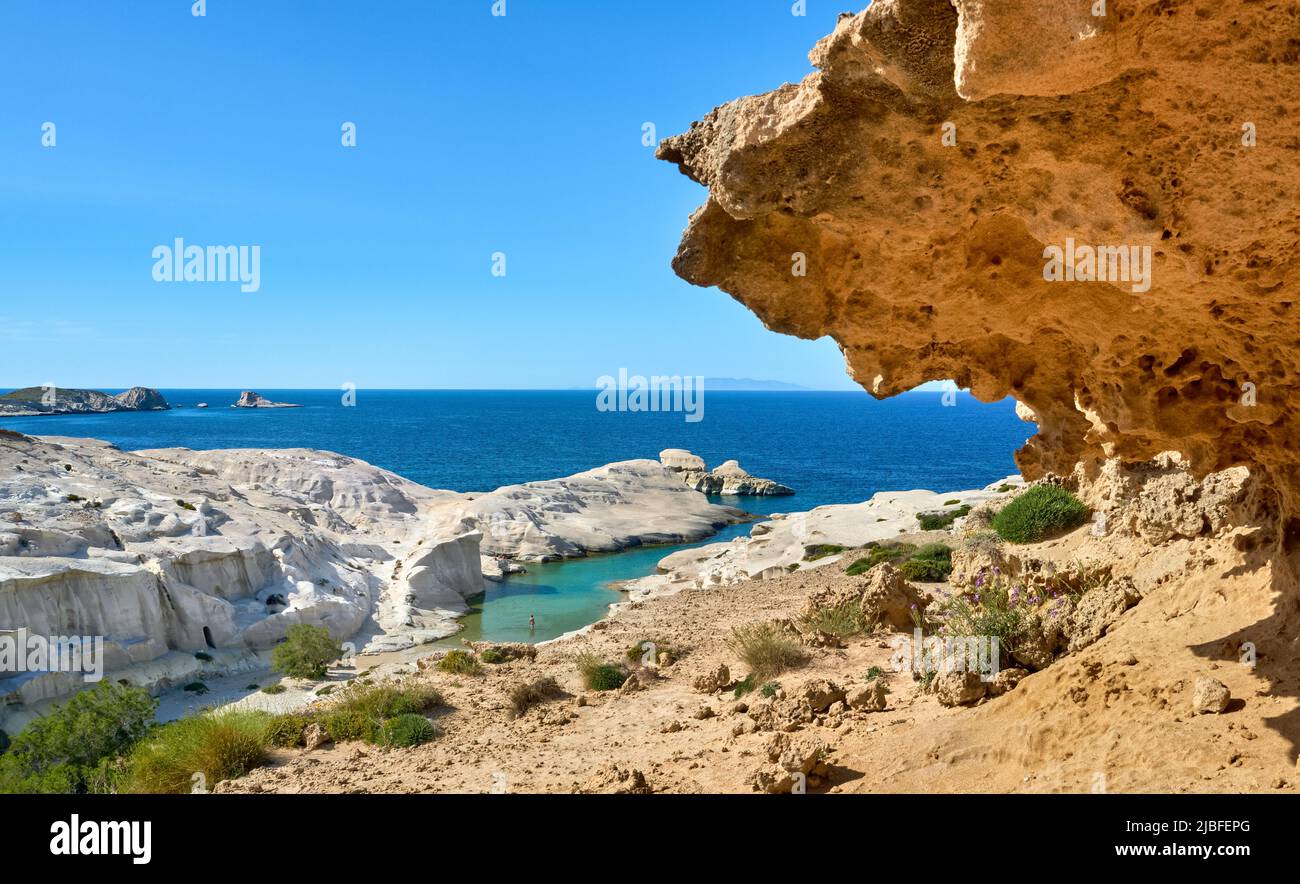 Famous white rocks of Sarakiniko beach, Aegean sea, Milos island , Greece. Empty cliffs, summer sunshine, big orange rock, clear sea waters and lagoon Stock Photo