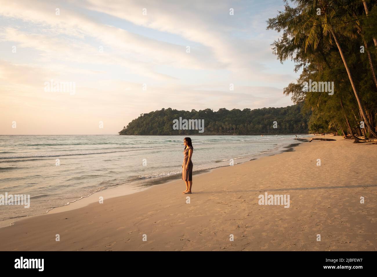 Woman on tropical beach at sunset Stock Photo