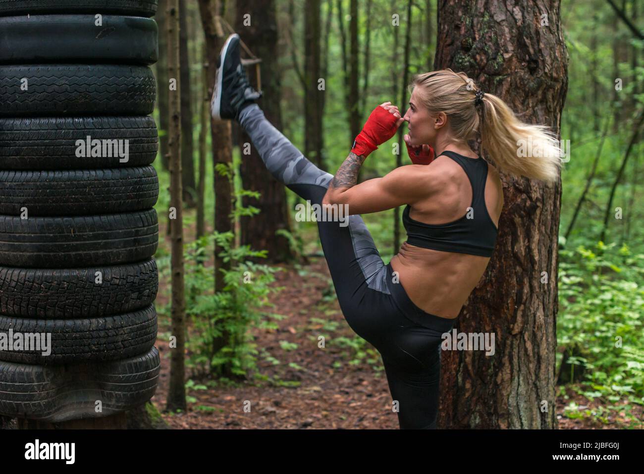 Woman fighter practising martial arts performing a leg axe kick working