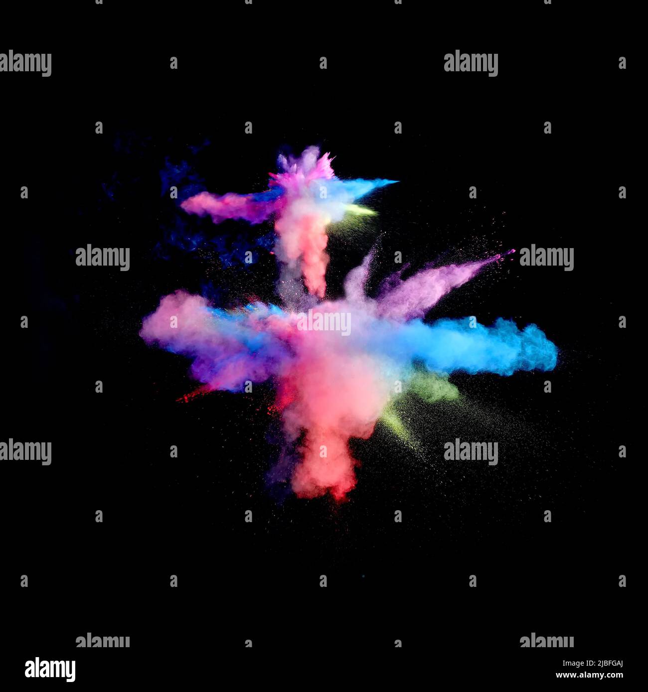 Various multicolored forms of powder paint explode in front of a black ...