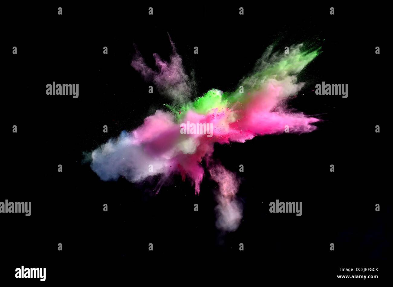 Various multicolored forms of powder paint explode in front of a black ...