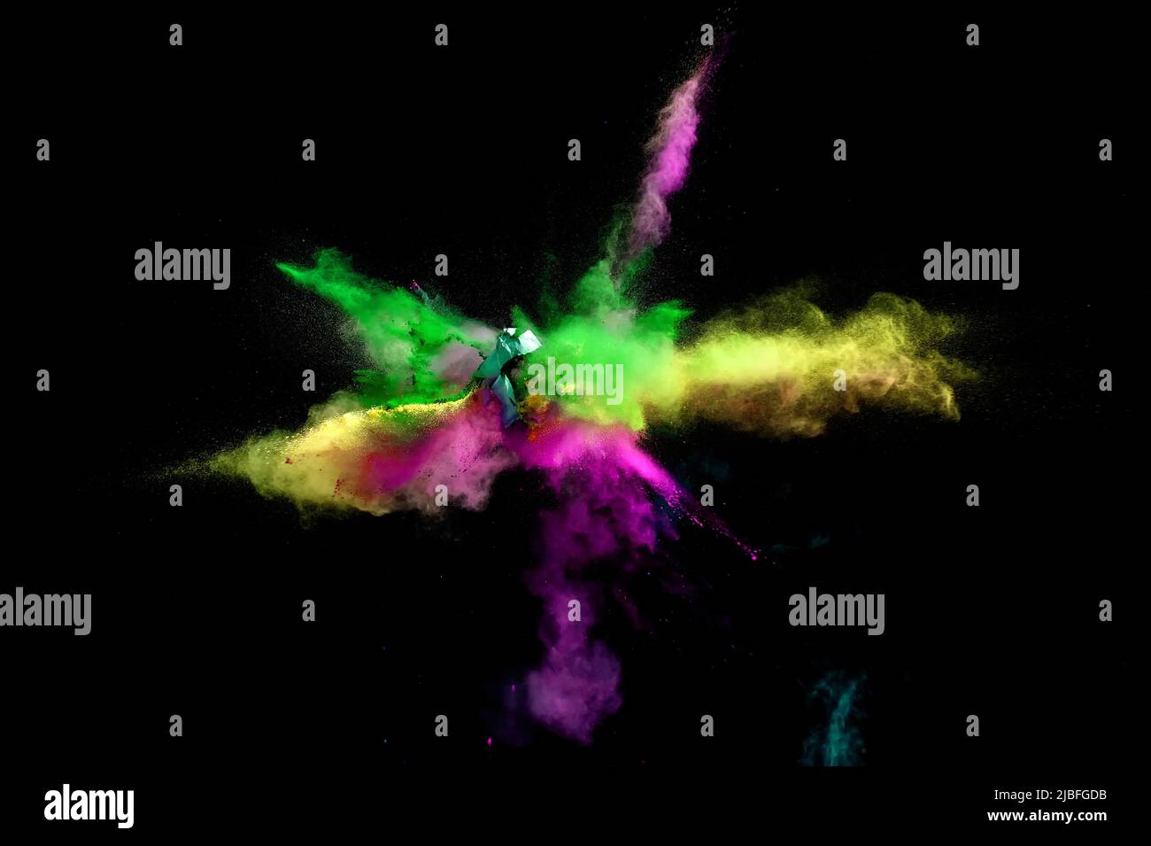 Various multicolored forms of powder paint explode in front of a black ...