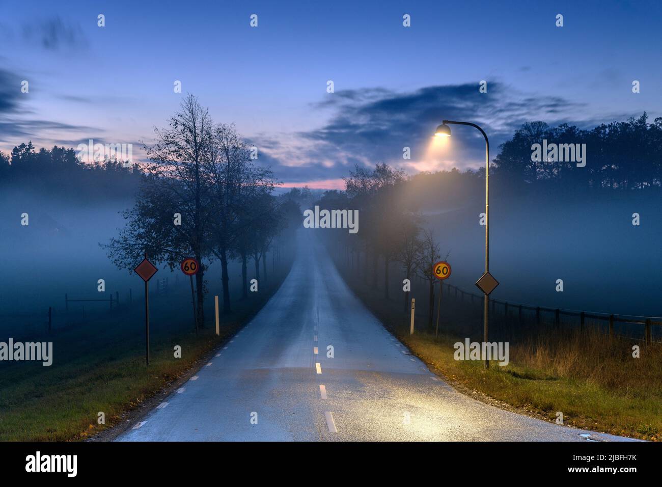 Street light by road at sunset Stock Photo