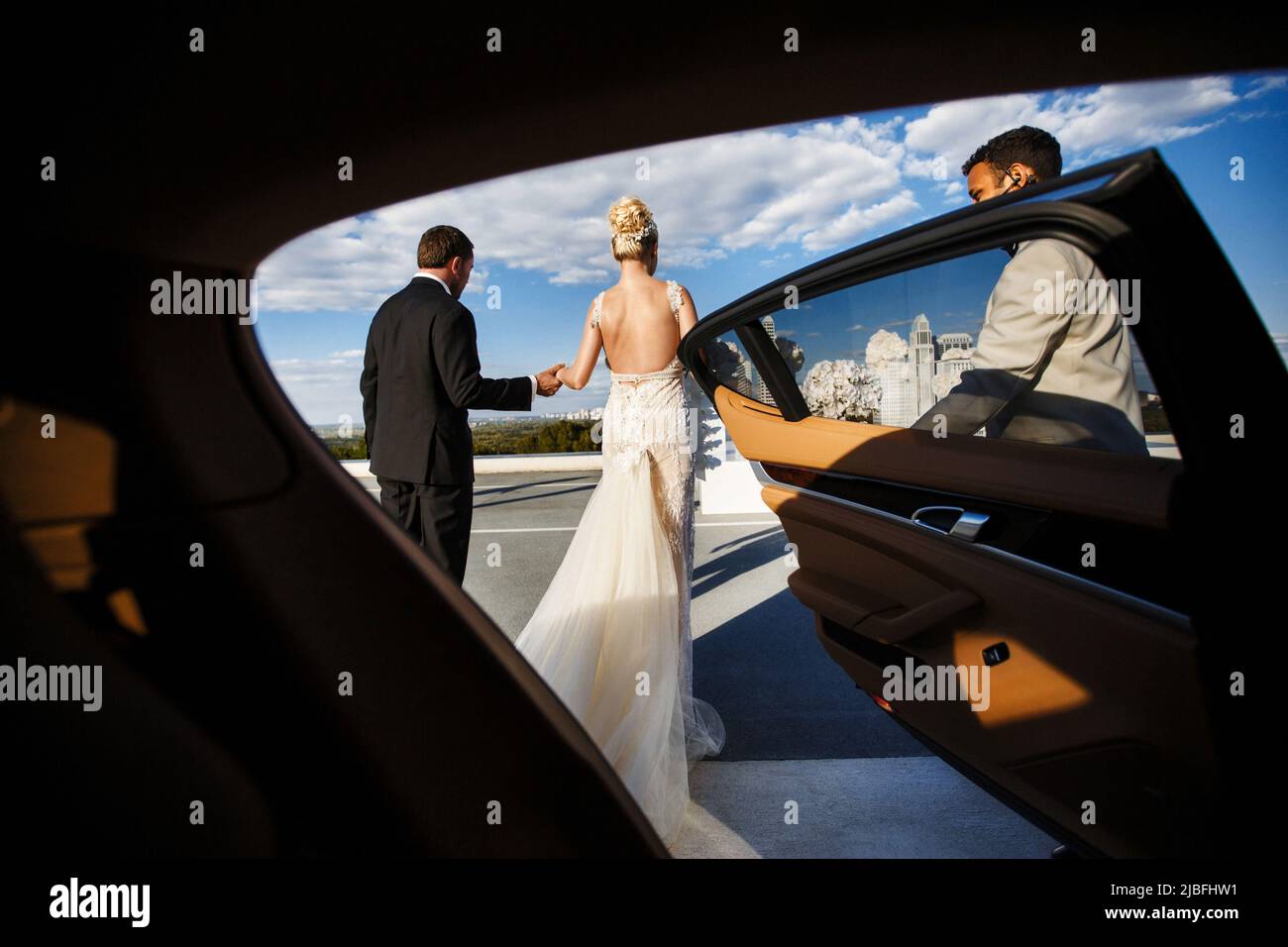 The bride and groom get out of the car and walk together at the wedding ...