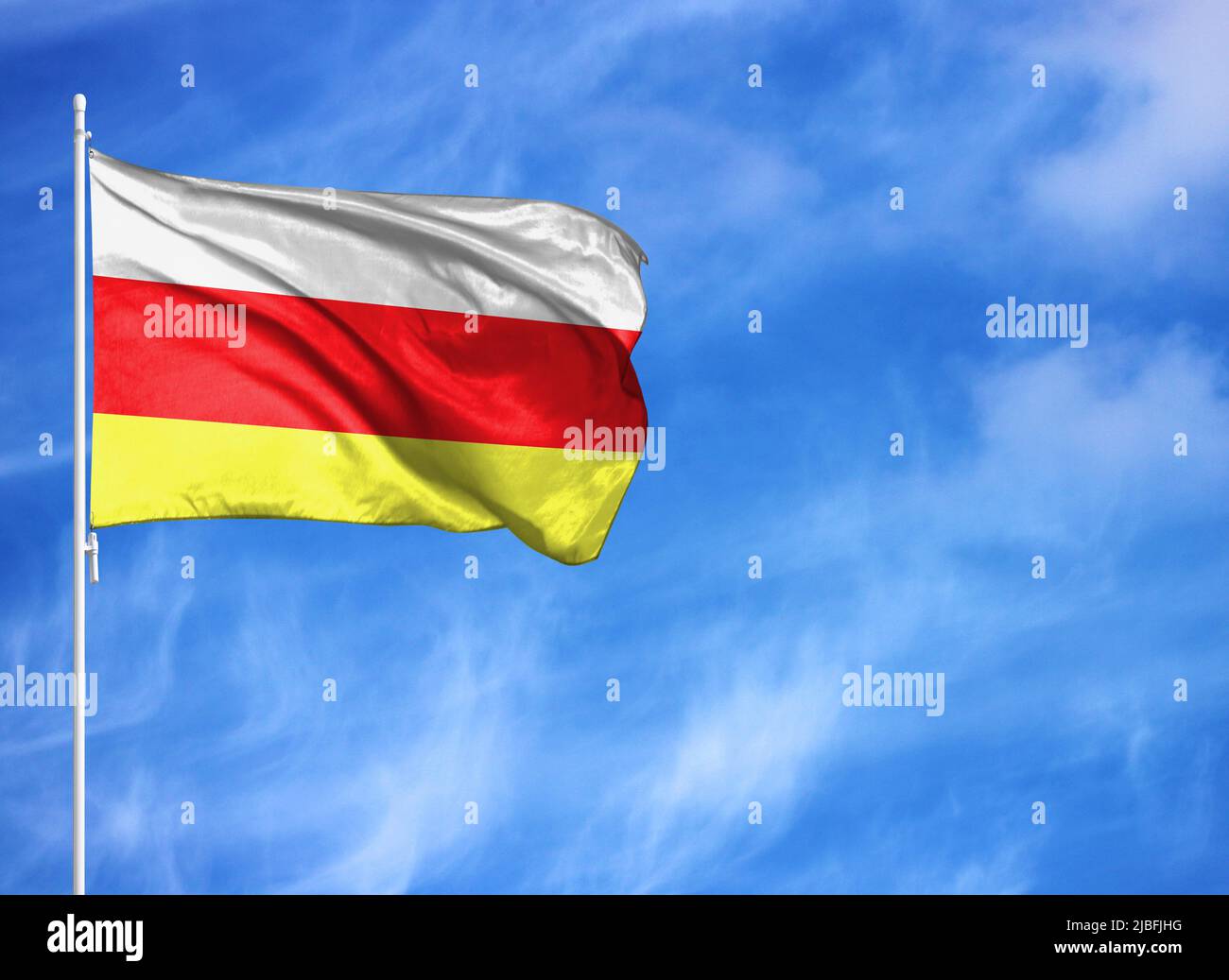 National flag of North Ossetia on a flagpole Stock Photo