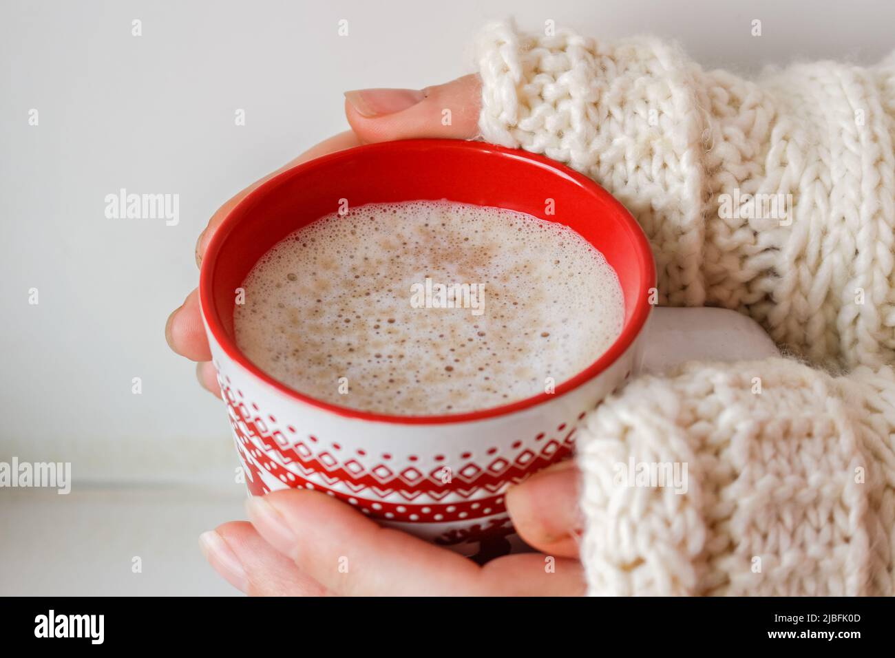Woman's hand holding a Cup of hot coffee in a winter knitted sweater ...