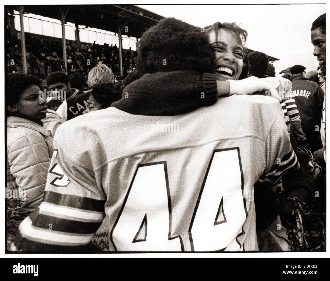 After a game, Canarsie High School football player gets hugged by a jubilant cheerleader. At Midwood Field in Brooklyn, New York. Stock Photo
