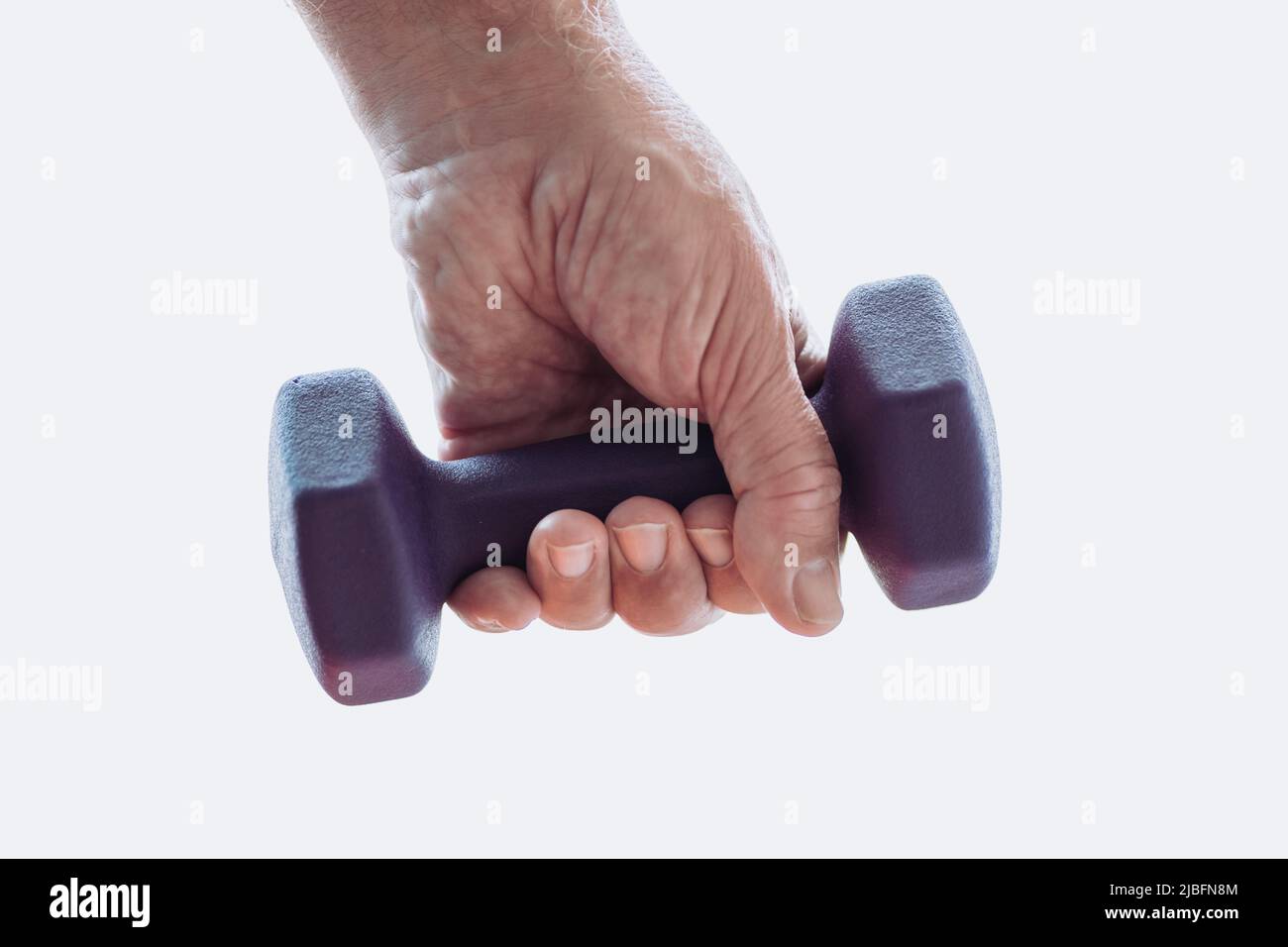Cropped unrecognizable senior male arm in sportswear doing exercise with dumbbells during fitness workout in morning at home Stock Photo