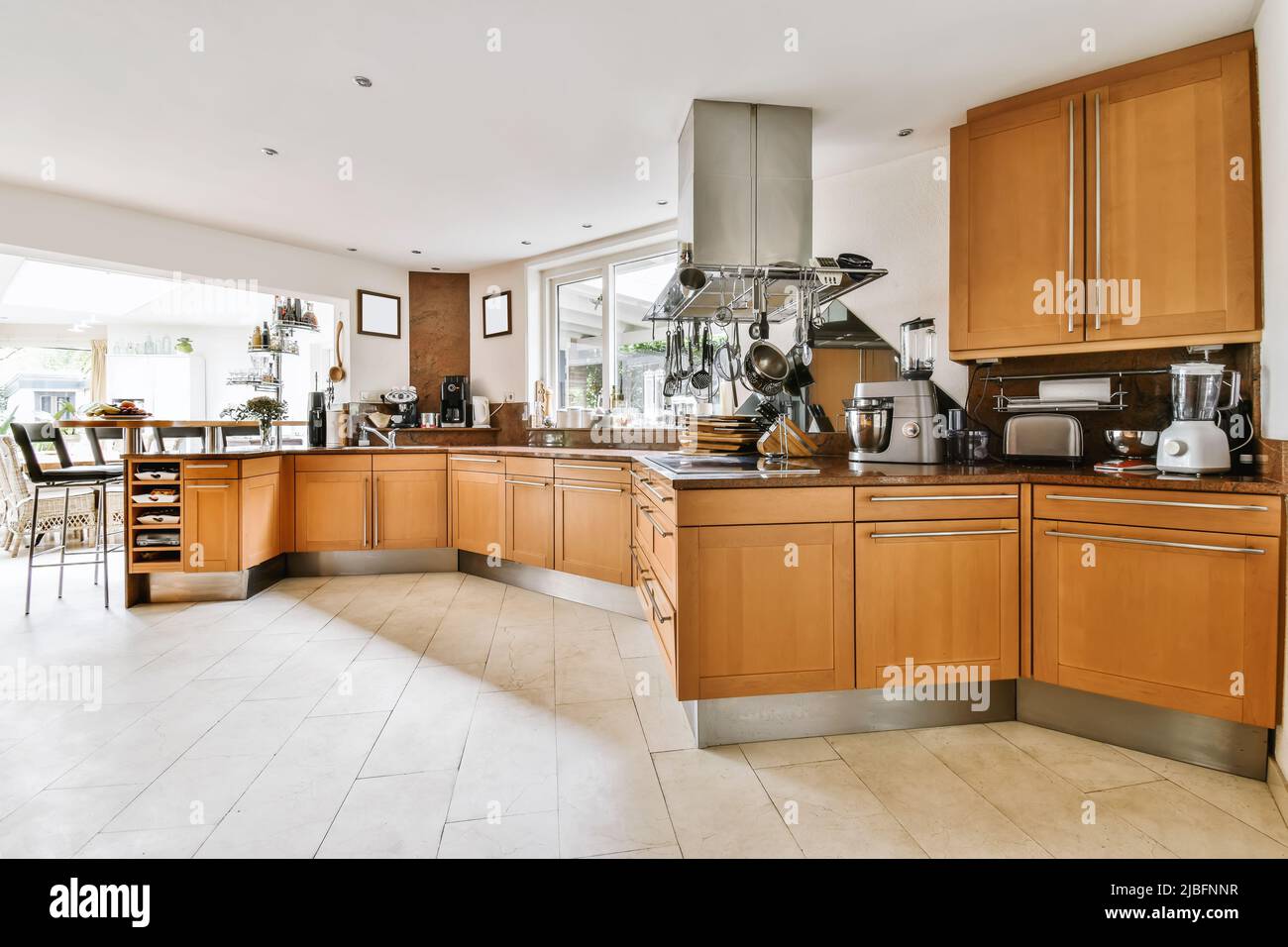 Interior of light spacious kitchen with brown furniture and modern