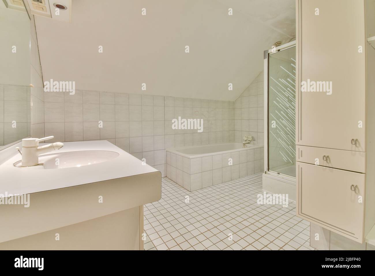White ceramic bathtub and sinks with mirror and cupboards near shower cabin in spacious modern